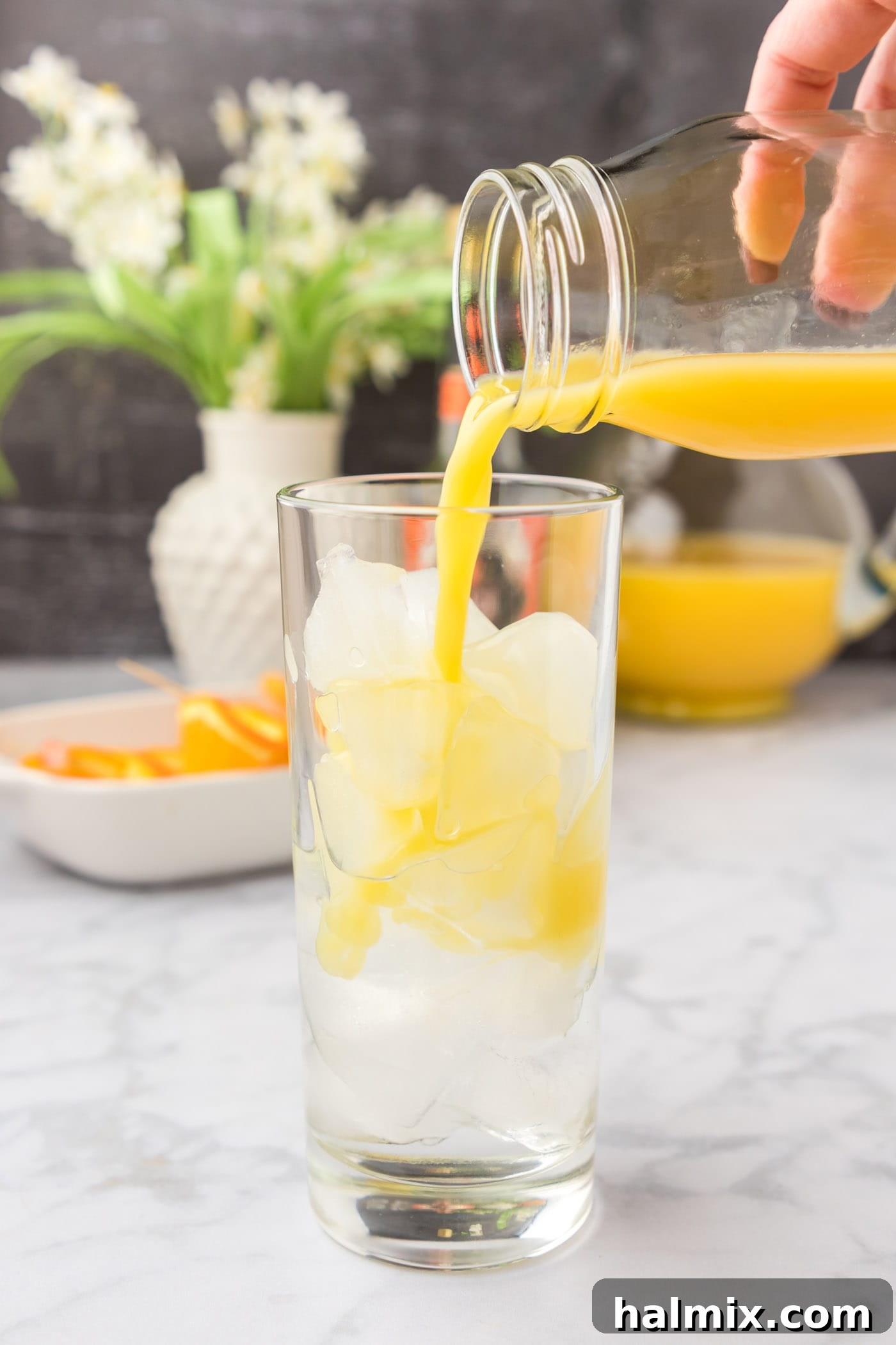 Velvet Peach Sunset 6 Pouring orange juice into a glass of peach schnapps and ice