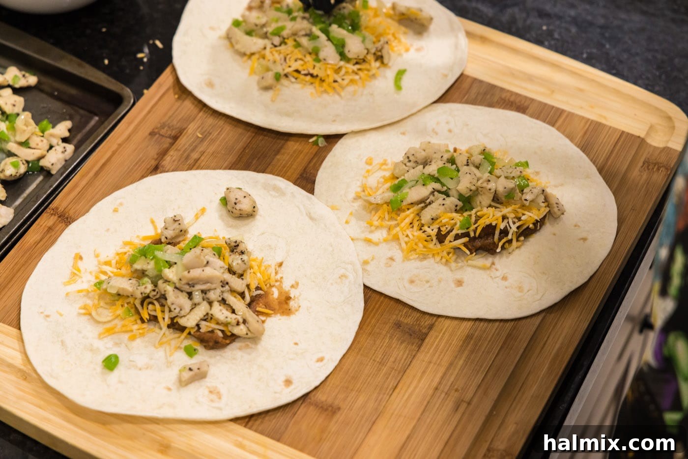 Deep-Fried Mexican Delights 13 vegetables added to cheese, beans, and chicken on a tortilla, completing the filling assembly