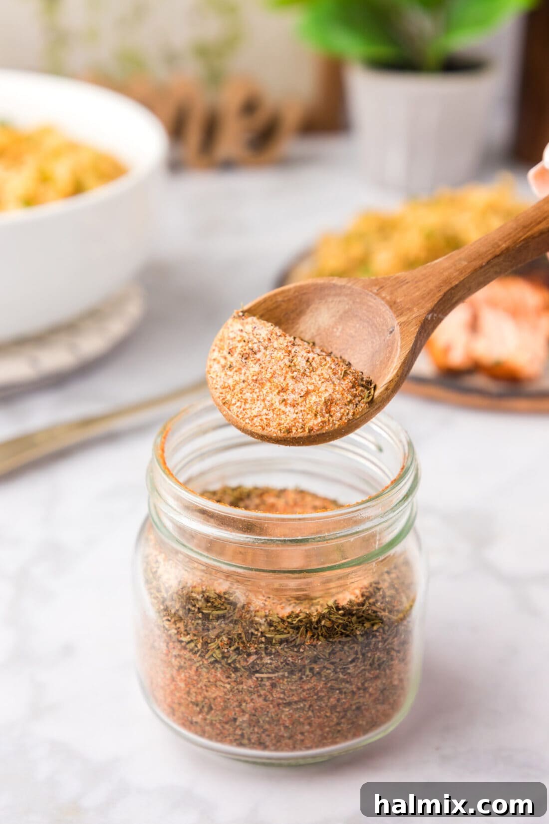 Spoonful of Cajun Seasoning being lifted out of a jar of Cajun Seasoning
