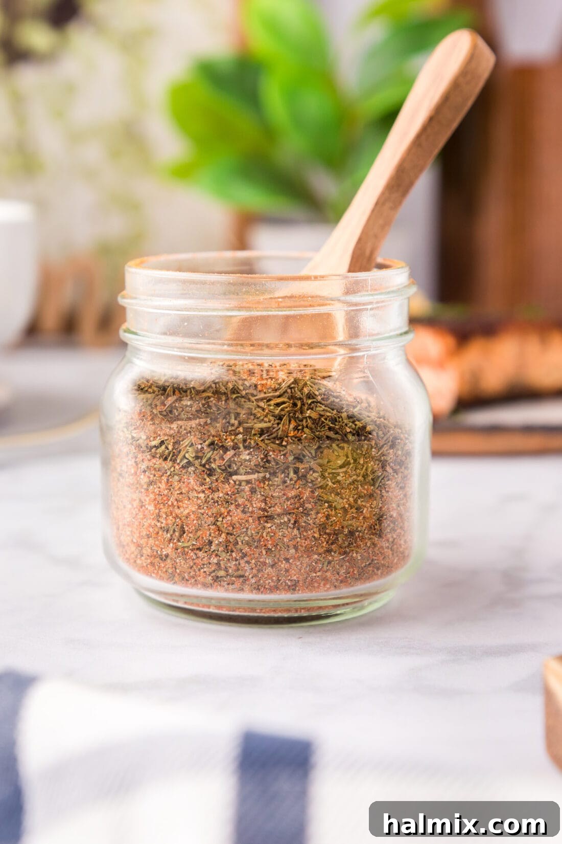 Jar of Cajun Seasoning with a wooden spoon in it