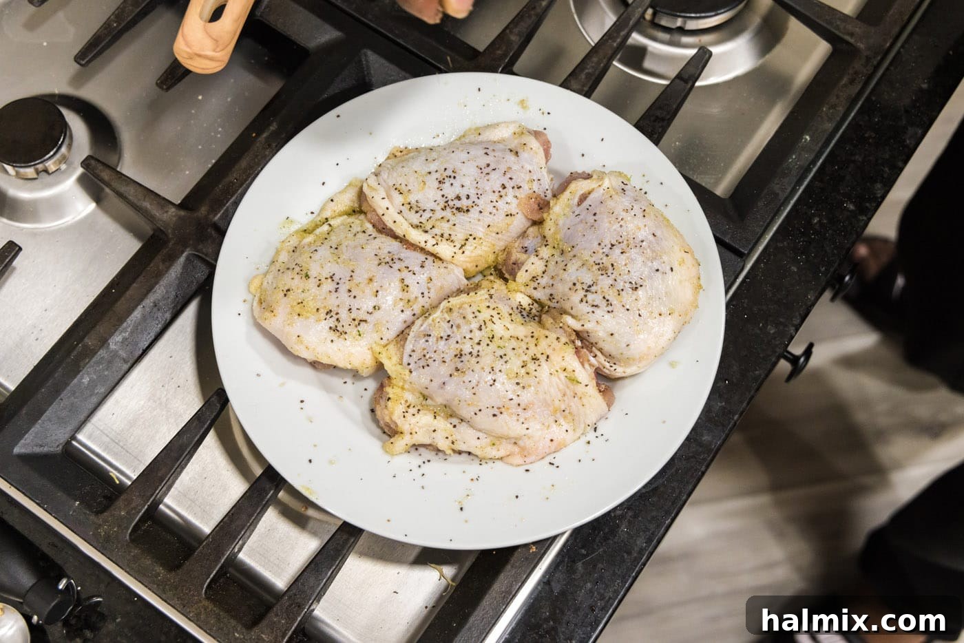 Seasoned chicken thighs on a plate, ready for searing in the Instant Pot.