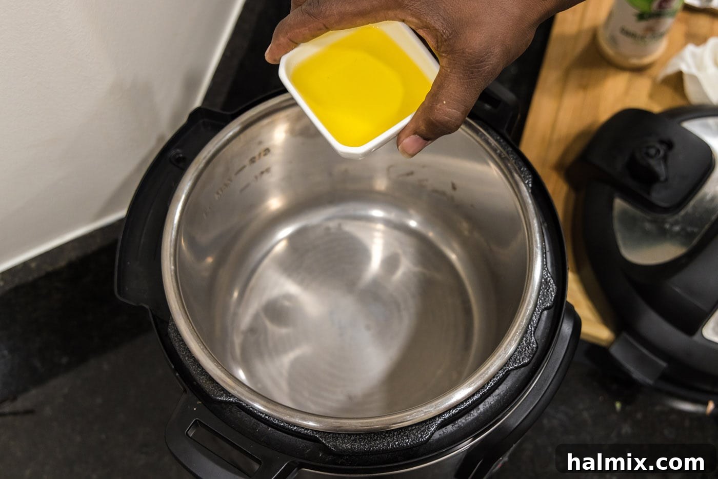 Adding olive oil to the bottom of the Instant Pot for searing.