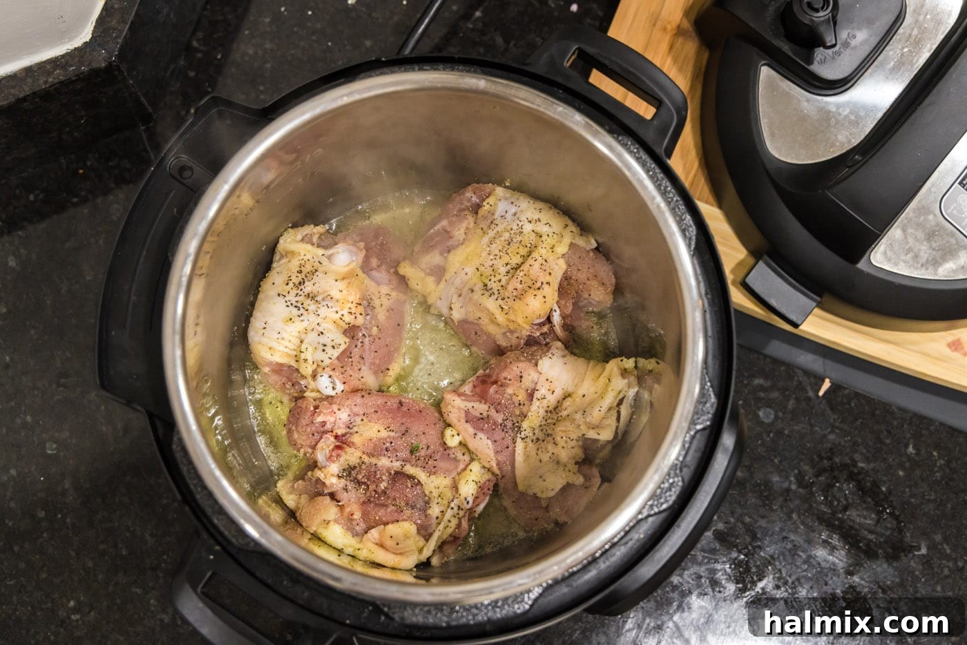 Searing chicken thighs in the Instant Pot until golden brown.