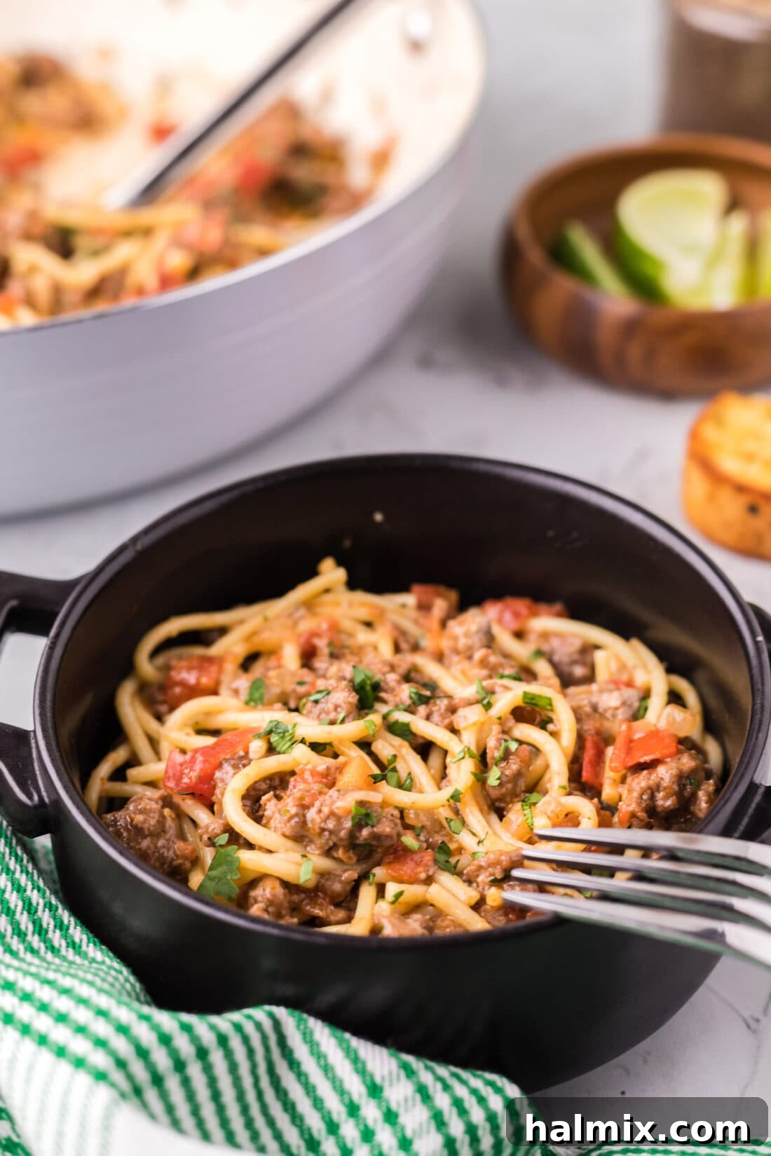 A bowl of delicious Taco Spaghetti, garnished with fresh cilantro, ready to be enjoyed. A fork rests invitingly on the side.