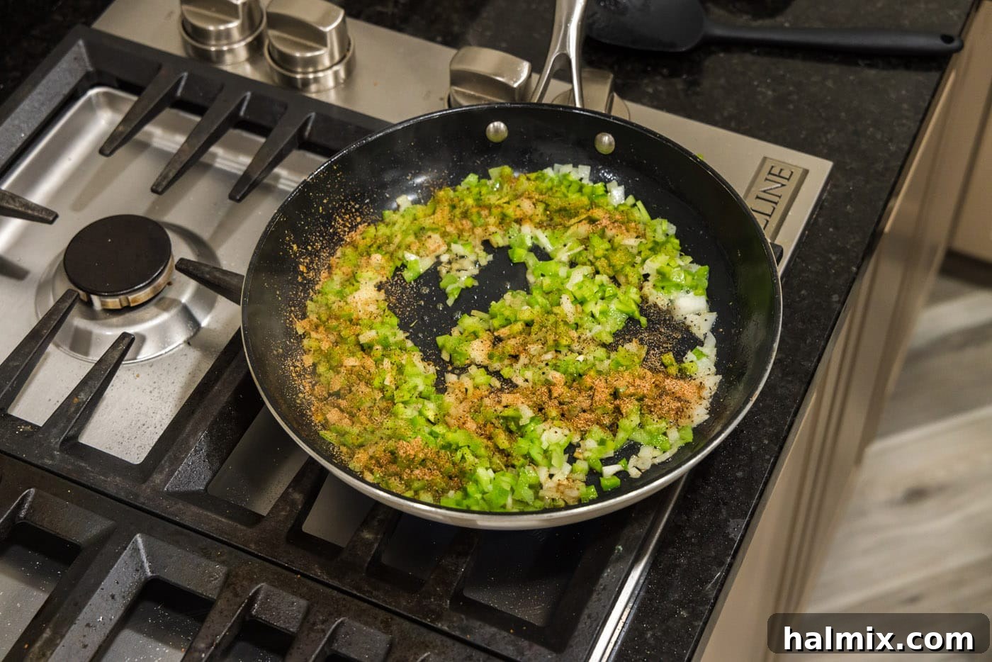 Spicy Southern Comfort Rice 6 Cajun seasoning generously sprinkled over the softened bell pepper, onion, and celery in the skillet, ready to be sautéed.