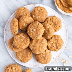 No Bake Peanut Butter Cookies on a plate with a bowl of peanut butter on the side