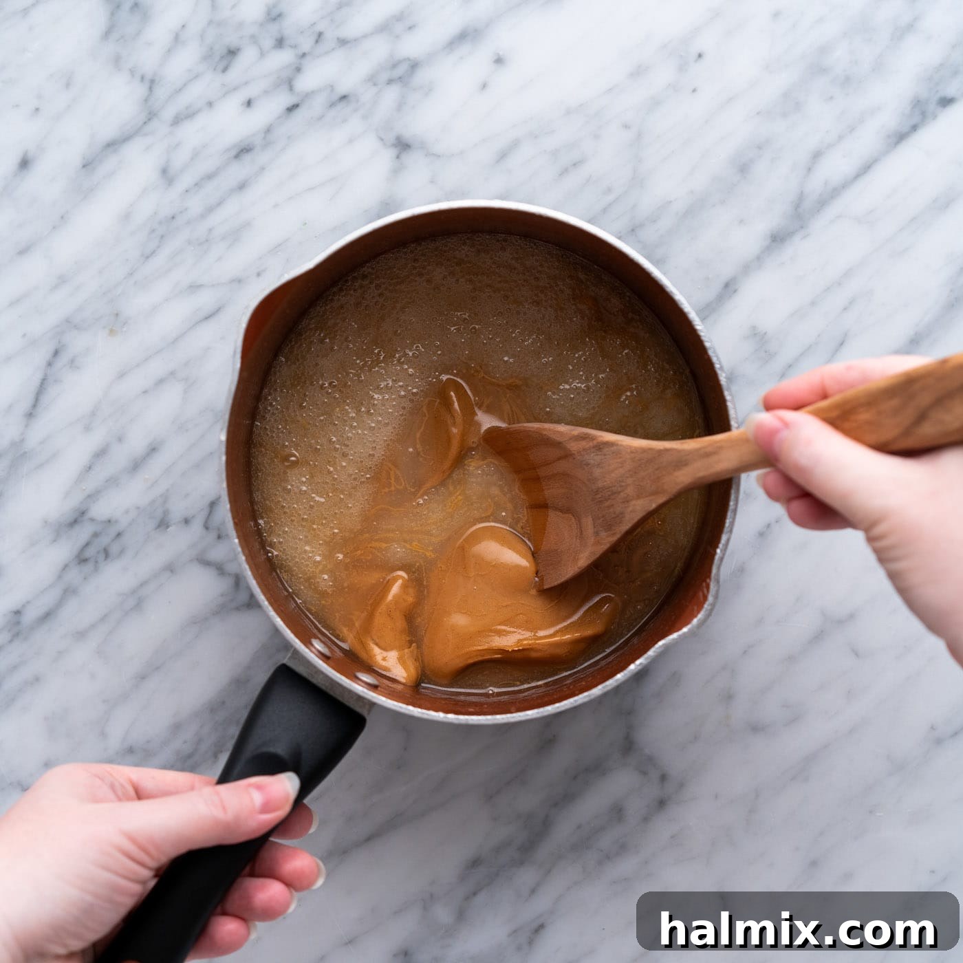 wooden spoon stirring peanut butter cookie mixture in a pan