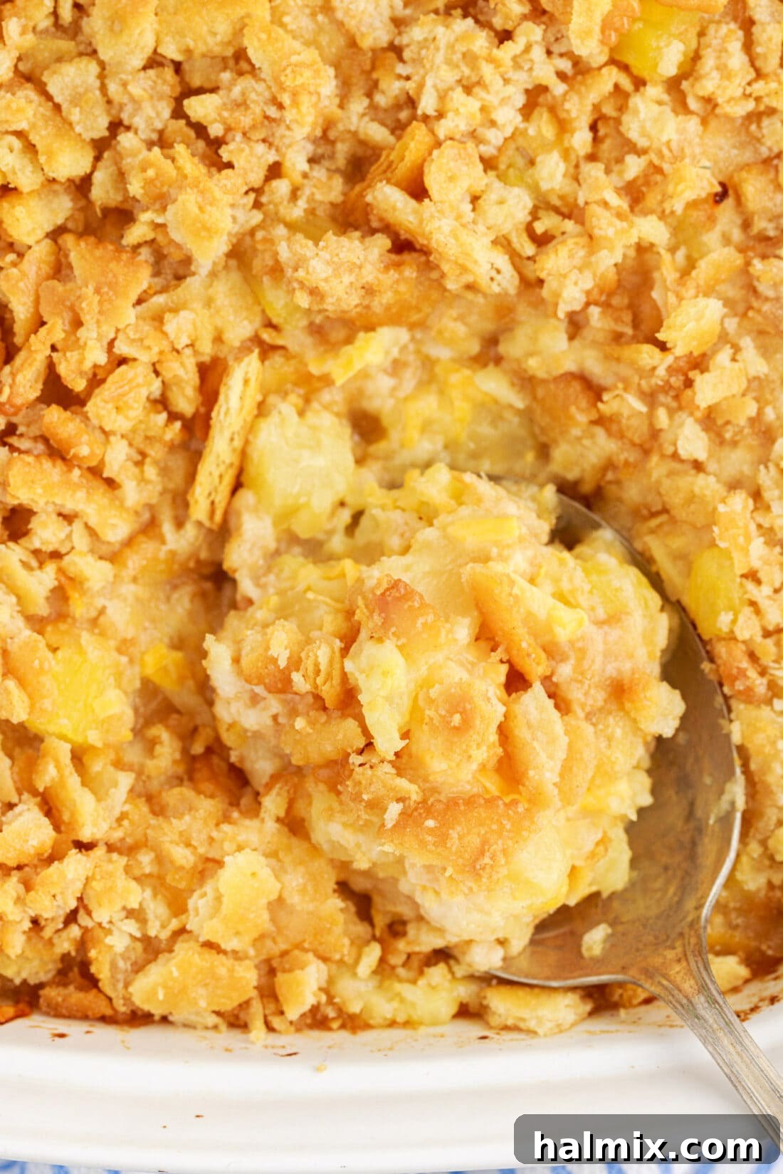 Close up photo of a spoon in a pan of Pineapple Casserole