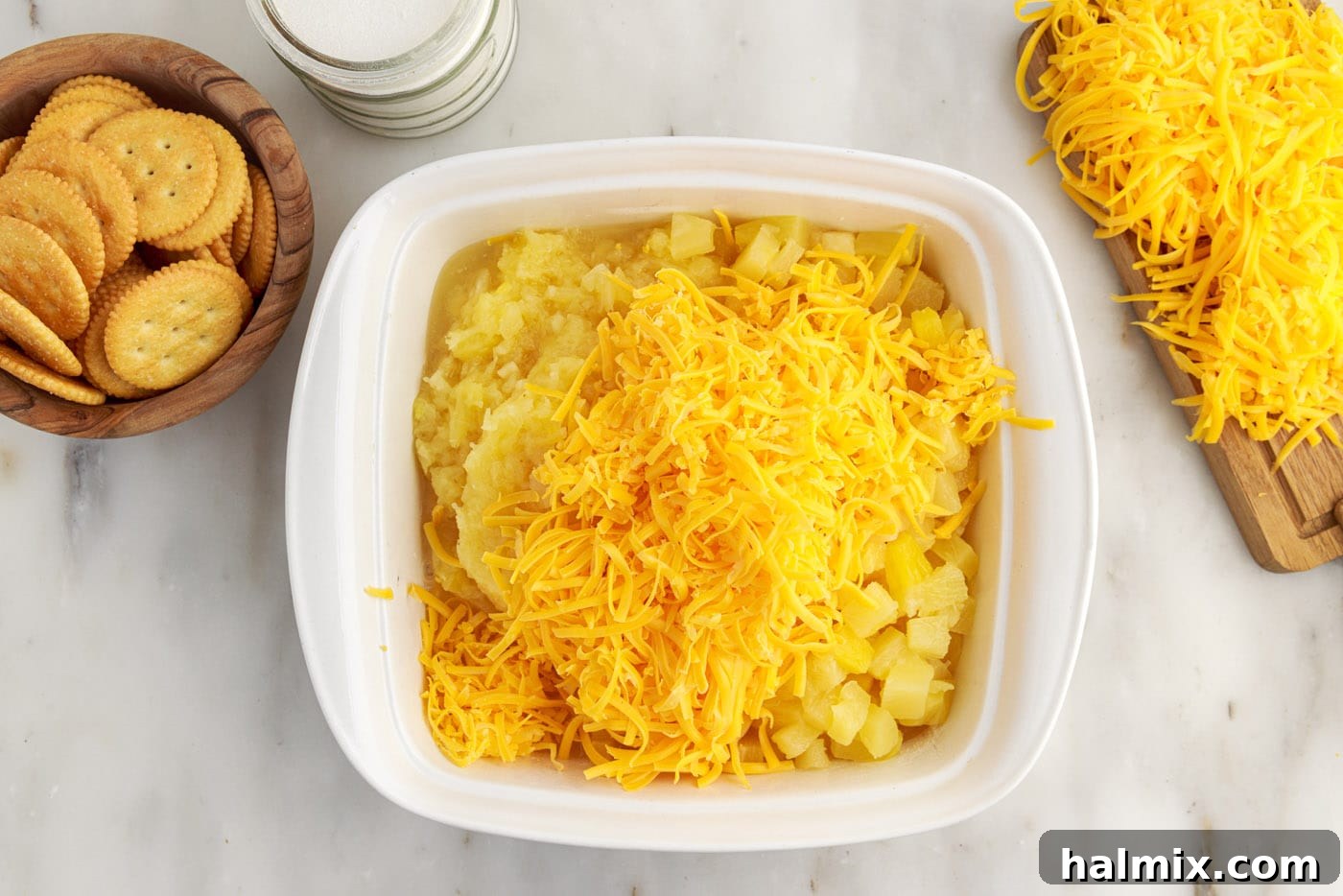 grated cheddar cheese and pineapple added to baking dish