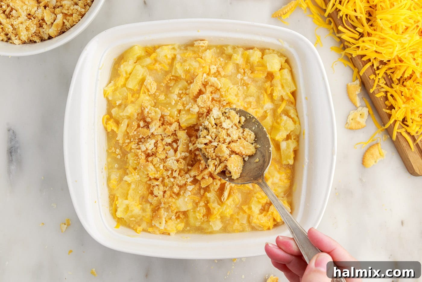 spreading ritz cracker topping over pineapple casserole