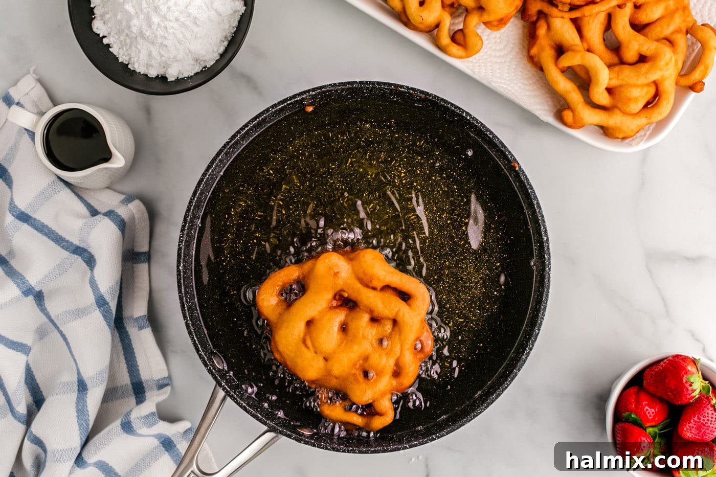 Golden Carnival Whirl 12 Golden fried funnel cake cooking in hot oil