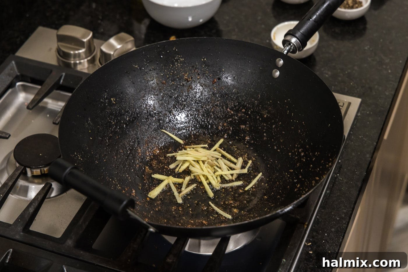 Slivered fresh ginger root sizzling in a small amount of oil in a hot wok.