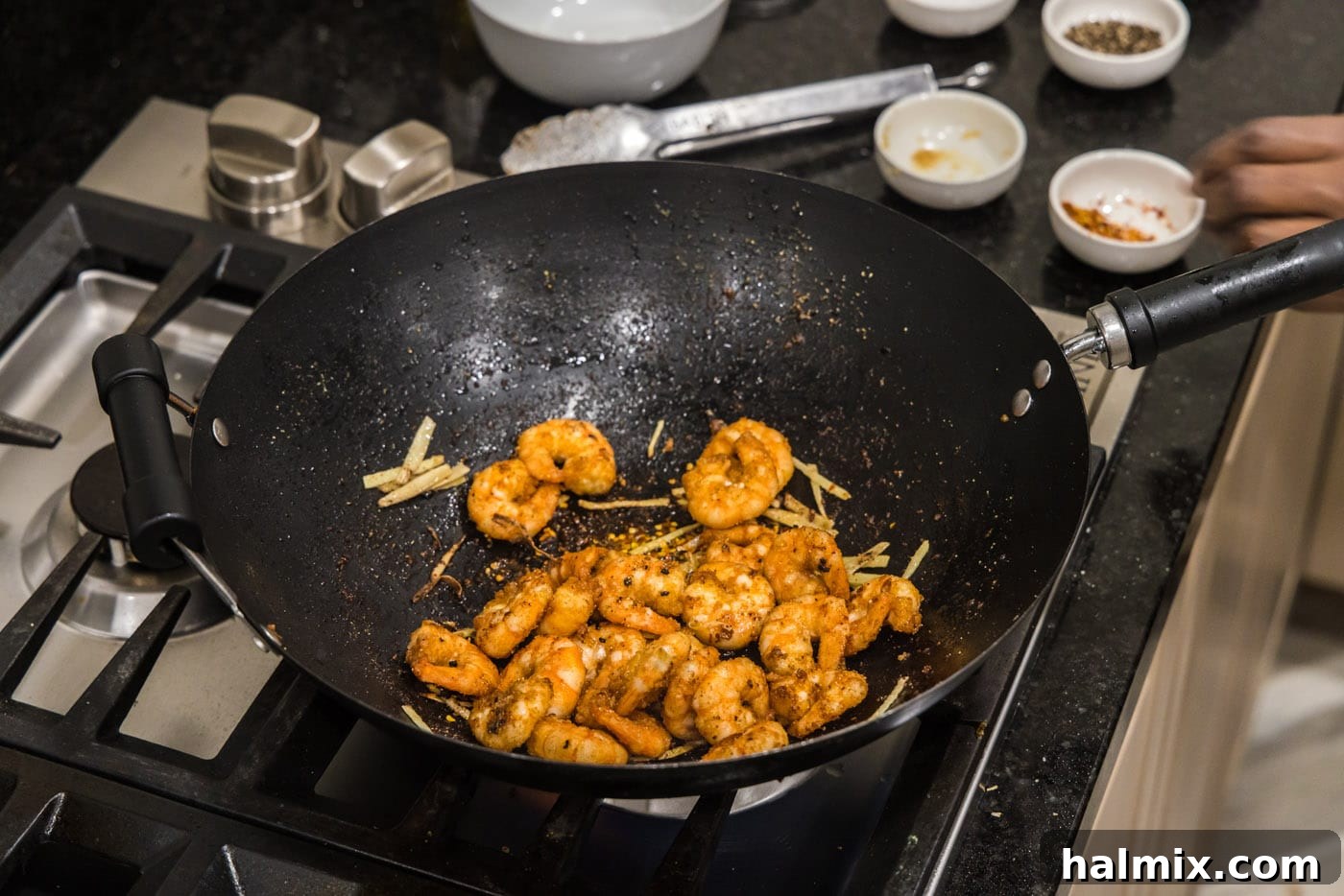 Fried shrimp returned to the wok with ginger and aromatics, ready for final seasoning.
