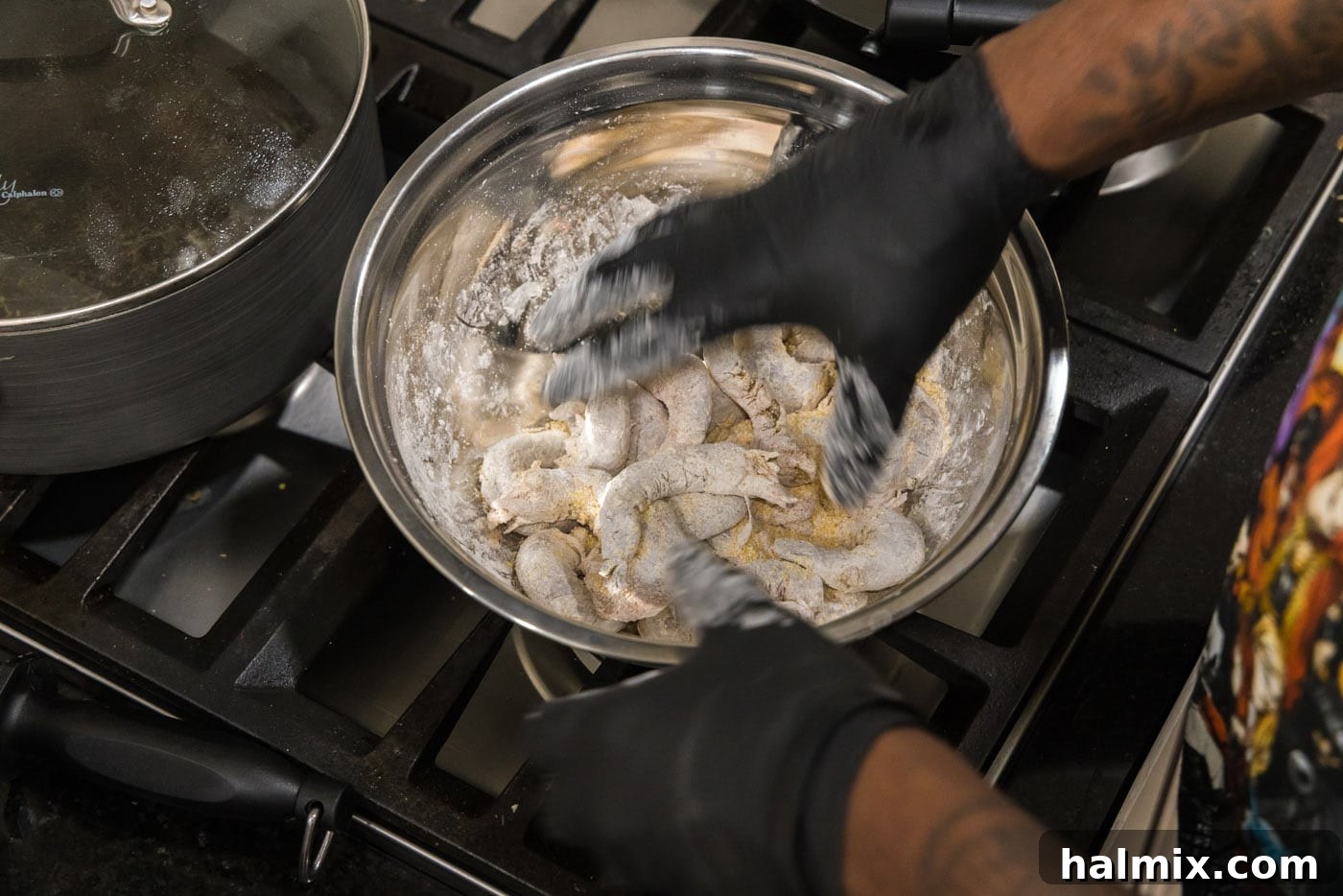 Tossing shrimp in a bowl with cornstarch and cornmeal until fully coated, showing the dry, crispy mixture.