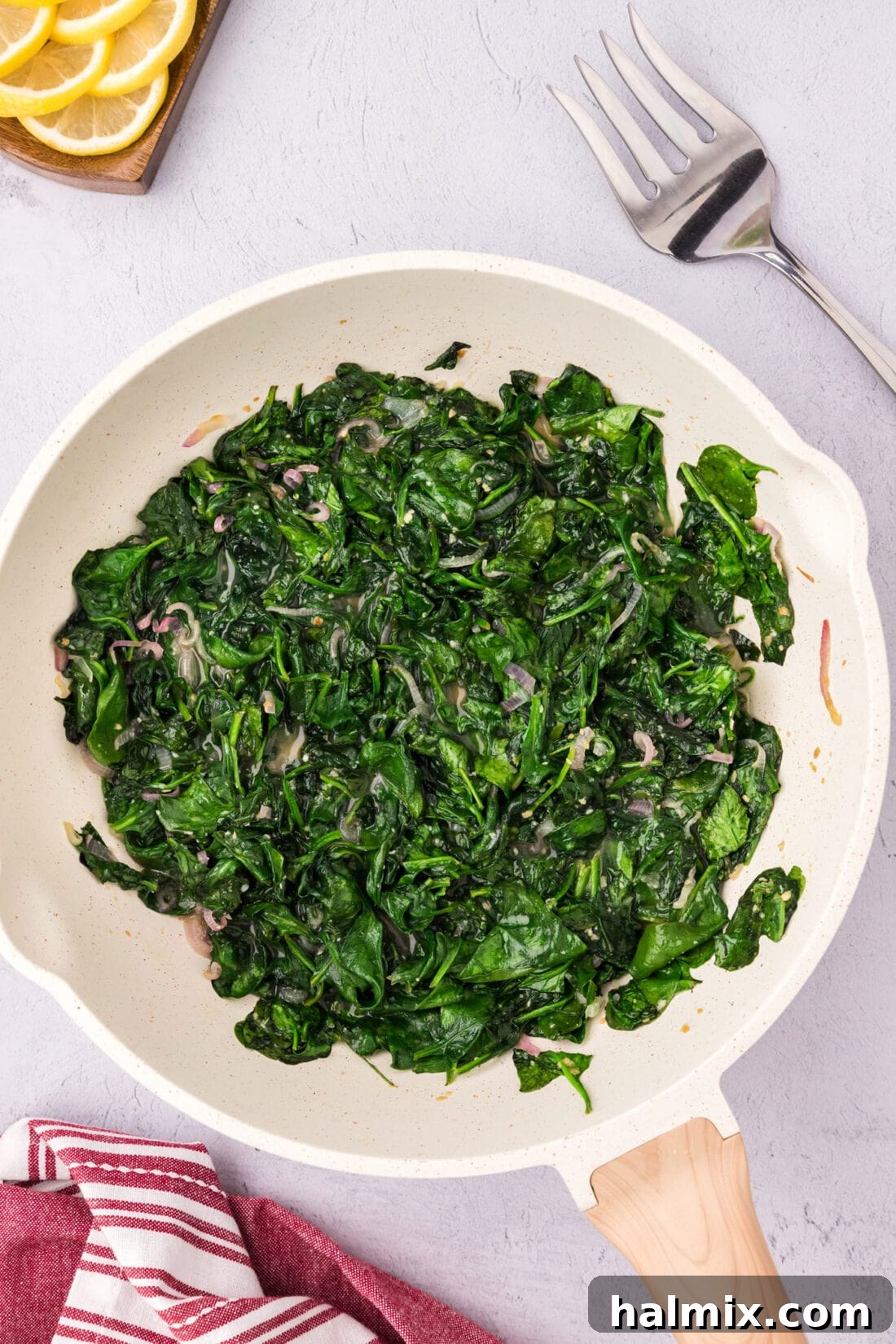 Freshly Sautéed Spinach gently wilting in a hot skillet.