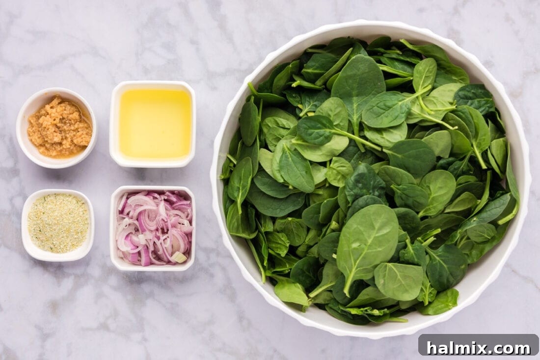 A selection of fresh ingredients including spinach, garlic, shallots, and olive oil for sautéed spinach.