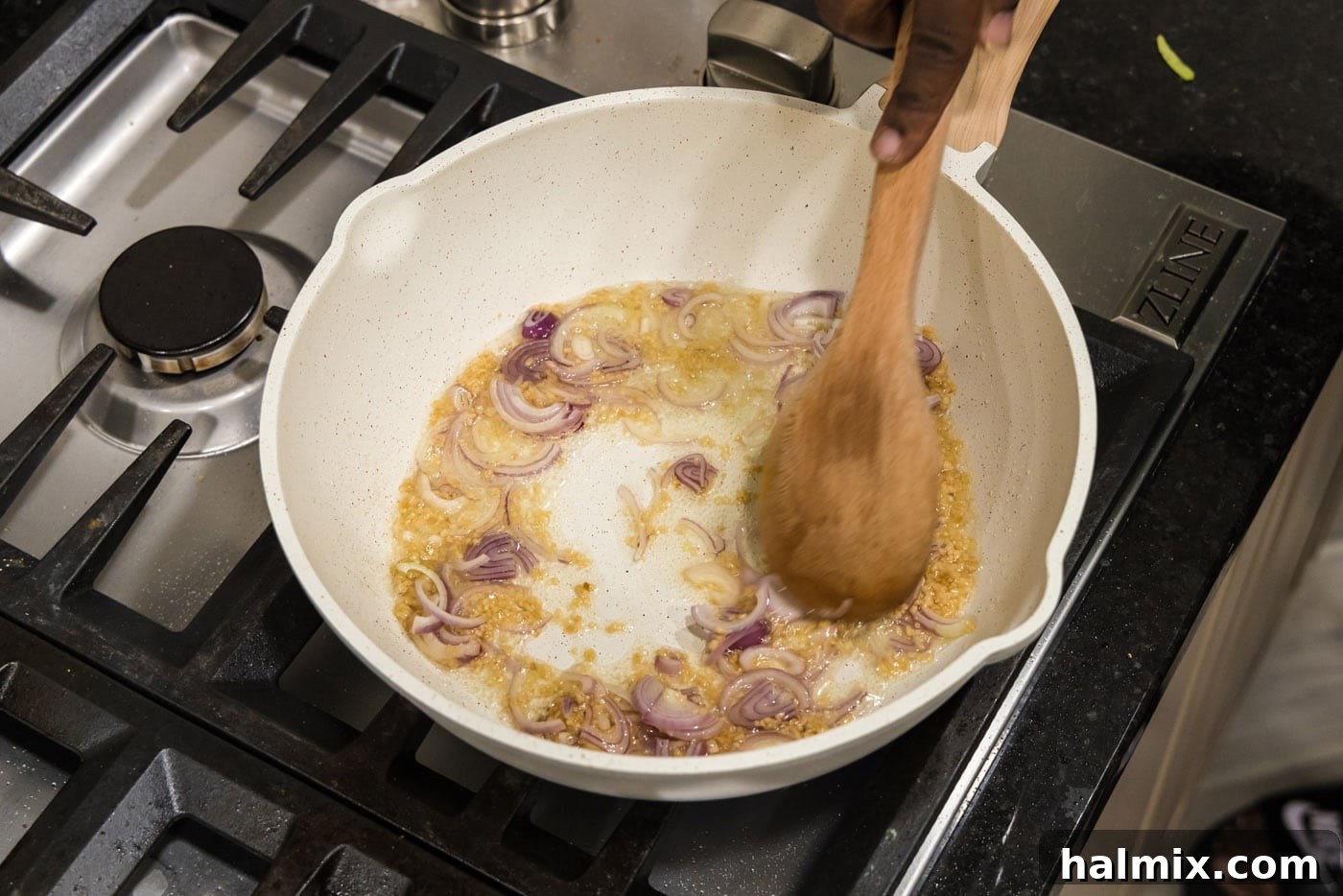 Gently mixing shallots and garlic in a pan to release their aromatic flavors.