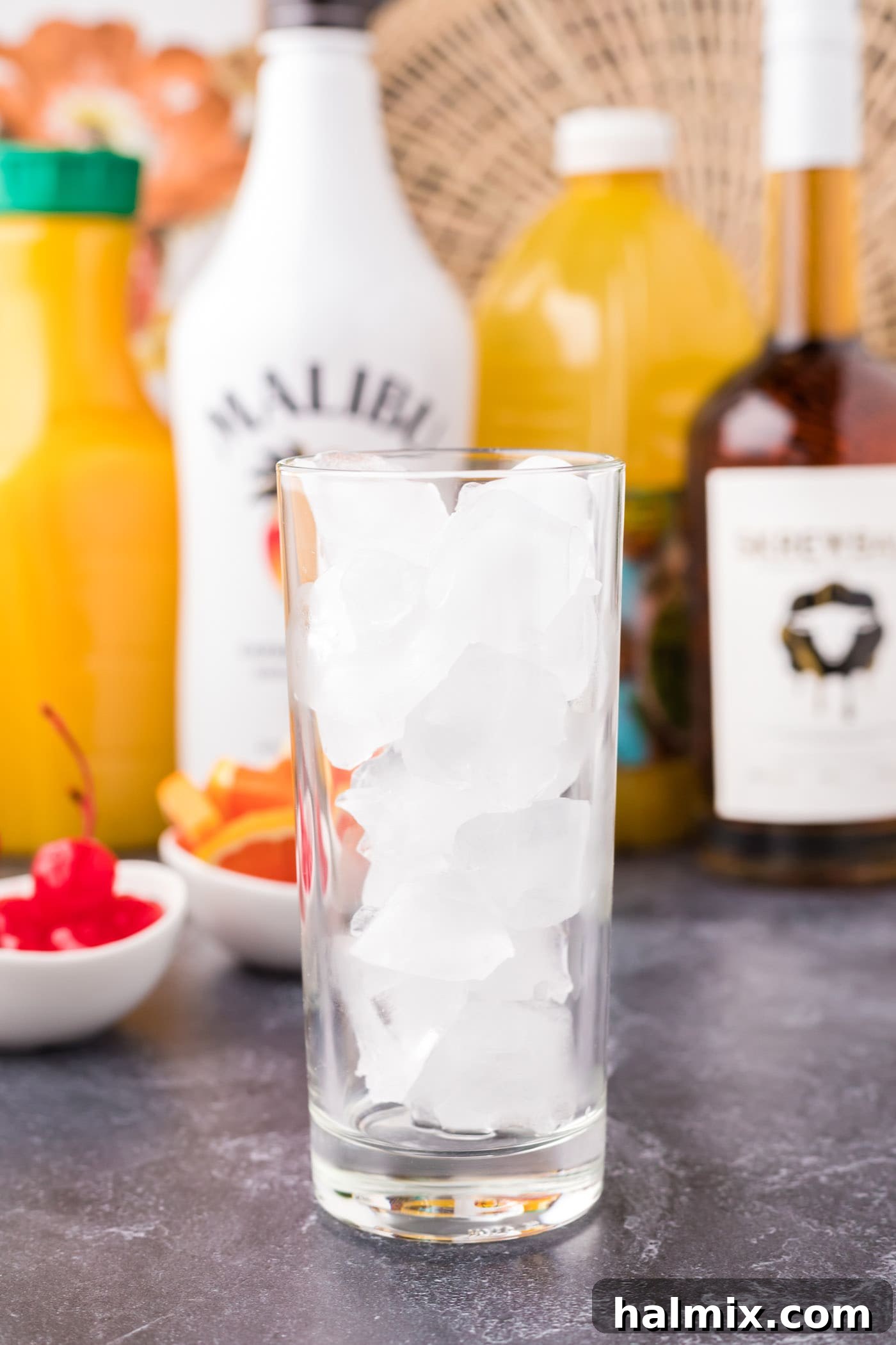 Highball glass filled halfway with ice cubes.