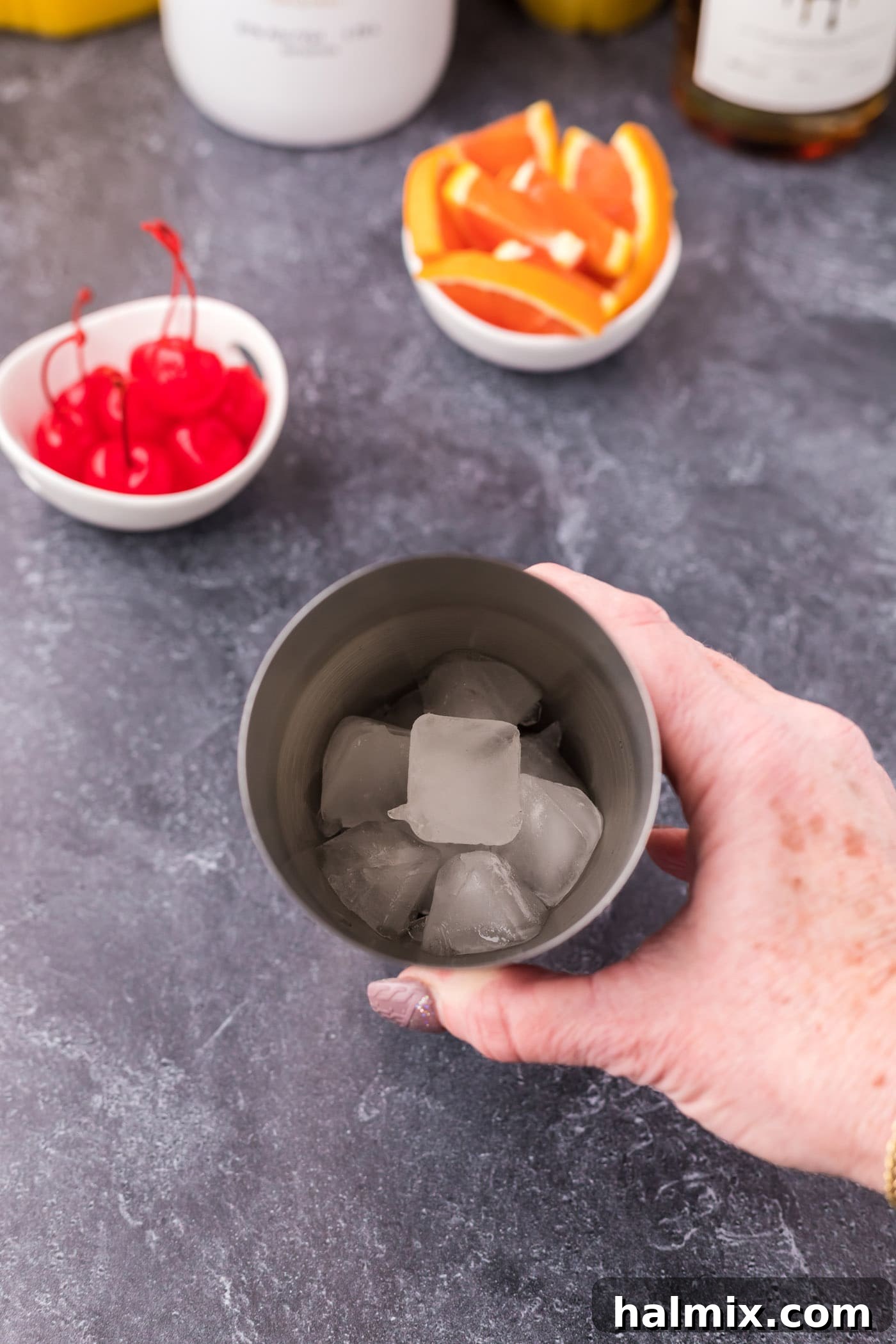 A cocktail shaker filled halfway with ice cubes.