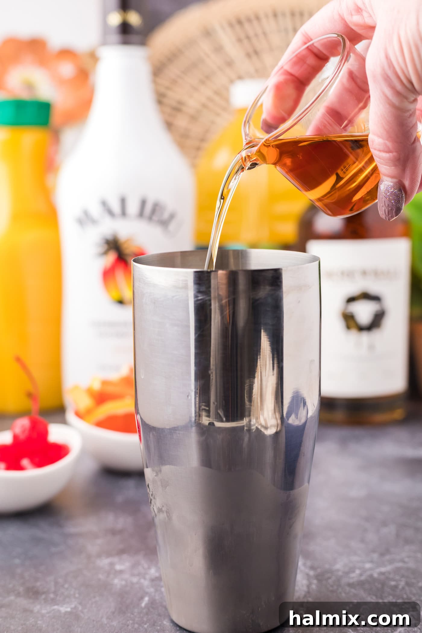 Pouring Skrewball peanut butter whiskey into a cocktail shaker.