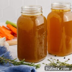 Close up photo of two jars of Homemade Chicken Stock, highlighting its texture and color.