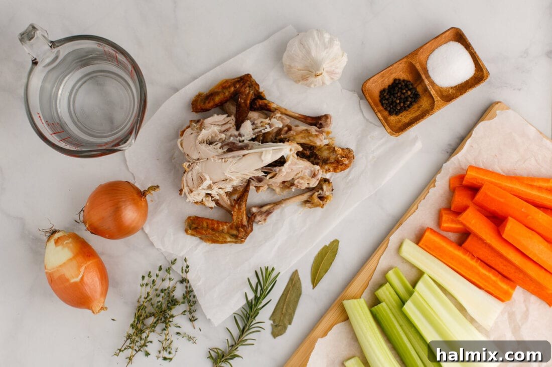 A vibrant selection of fresh ingredients laid out for making homemade chicken stock, including chicken carcasses, onions, carrots, celery, and herbs.