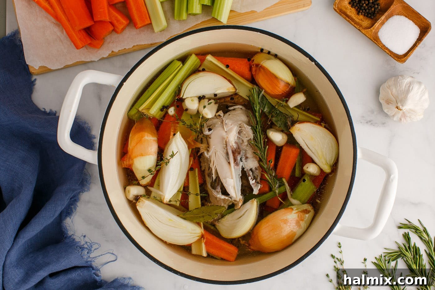 Cold water being added to fully cover the chicken and vegetables in the stockpot.