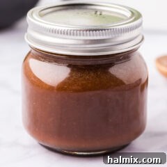Close up photo of a jar of Homemade Teriyaki Sauce, showcasing its rich, deep color and inviting texture.