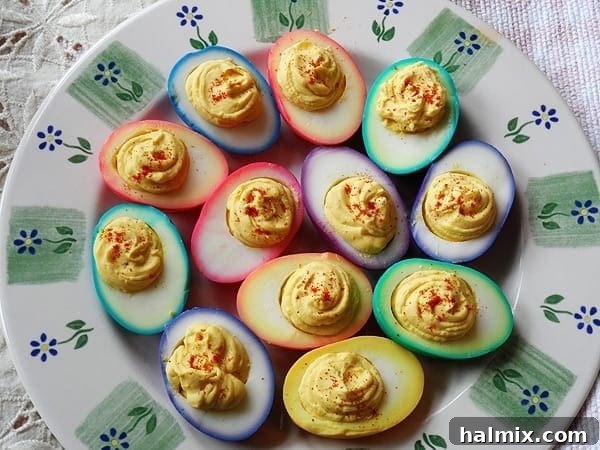 Rainbow Eggs: Two Ways to Delight 4 An inviting overhead view of a platter showcasing a variety of rainbow deviled eggs, artfully arranged with diverse colored fillings, ready for a festive gathering.