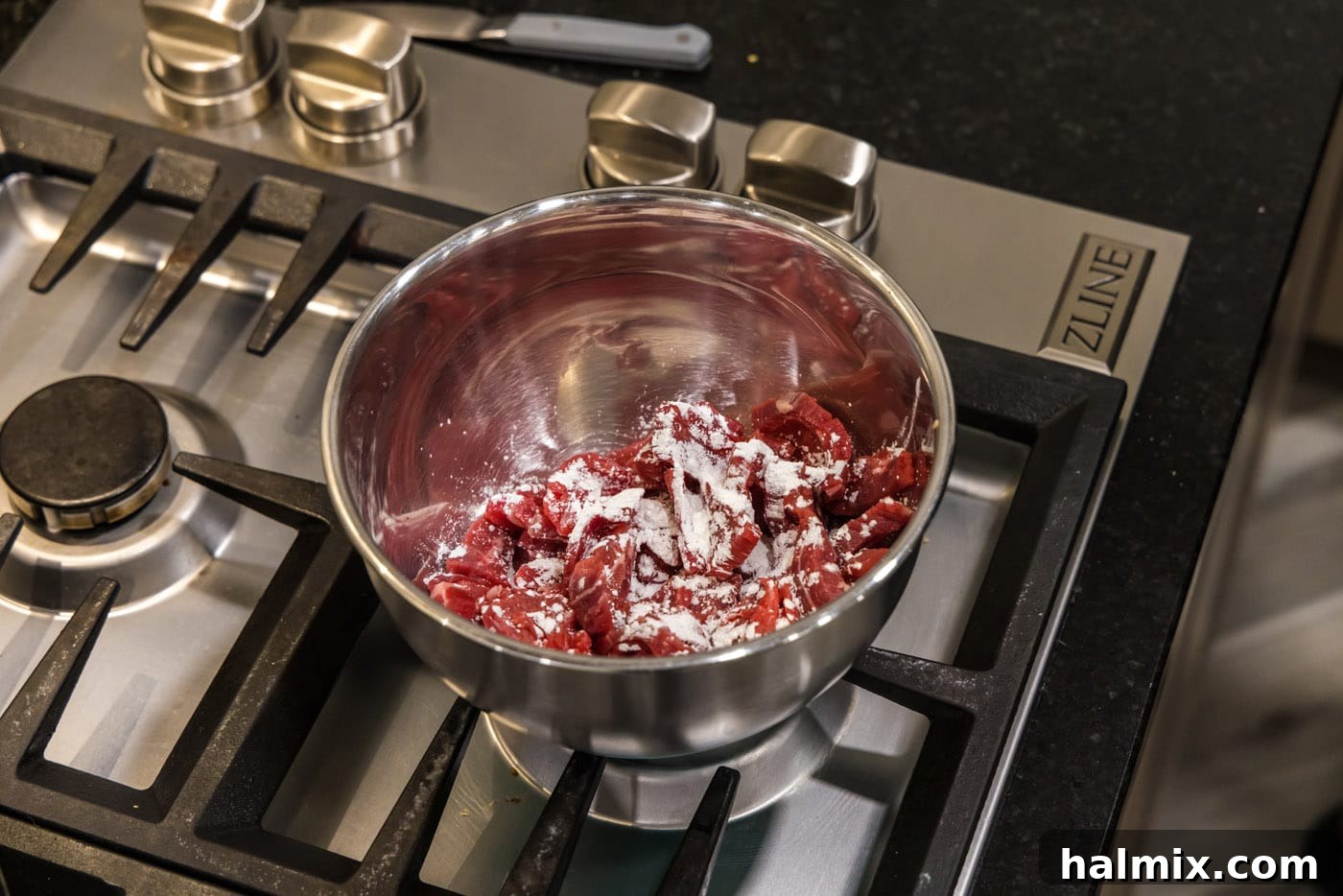 sliced flank steak with cornstarch in a bowl