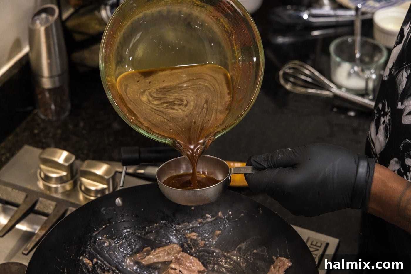 pouring teriyaki sauce into a measuring cup