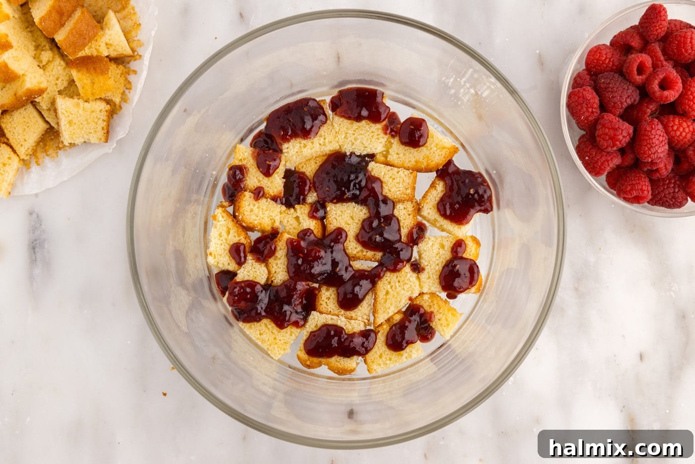 raspberry jam over pound cake in a trifle bowl