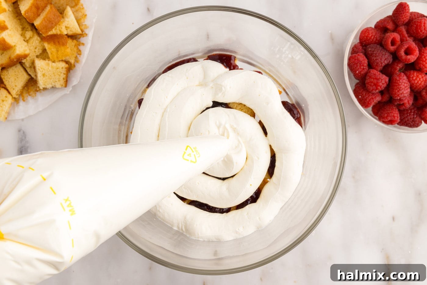 piping whipped cream cream cheese mixture over pound cake and jam