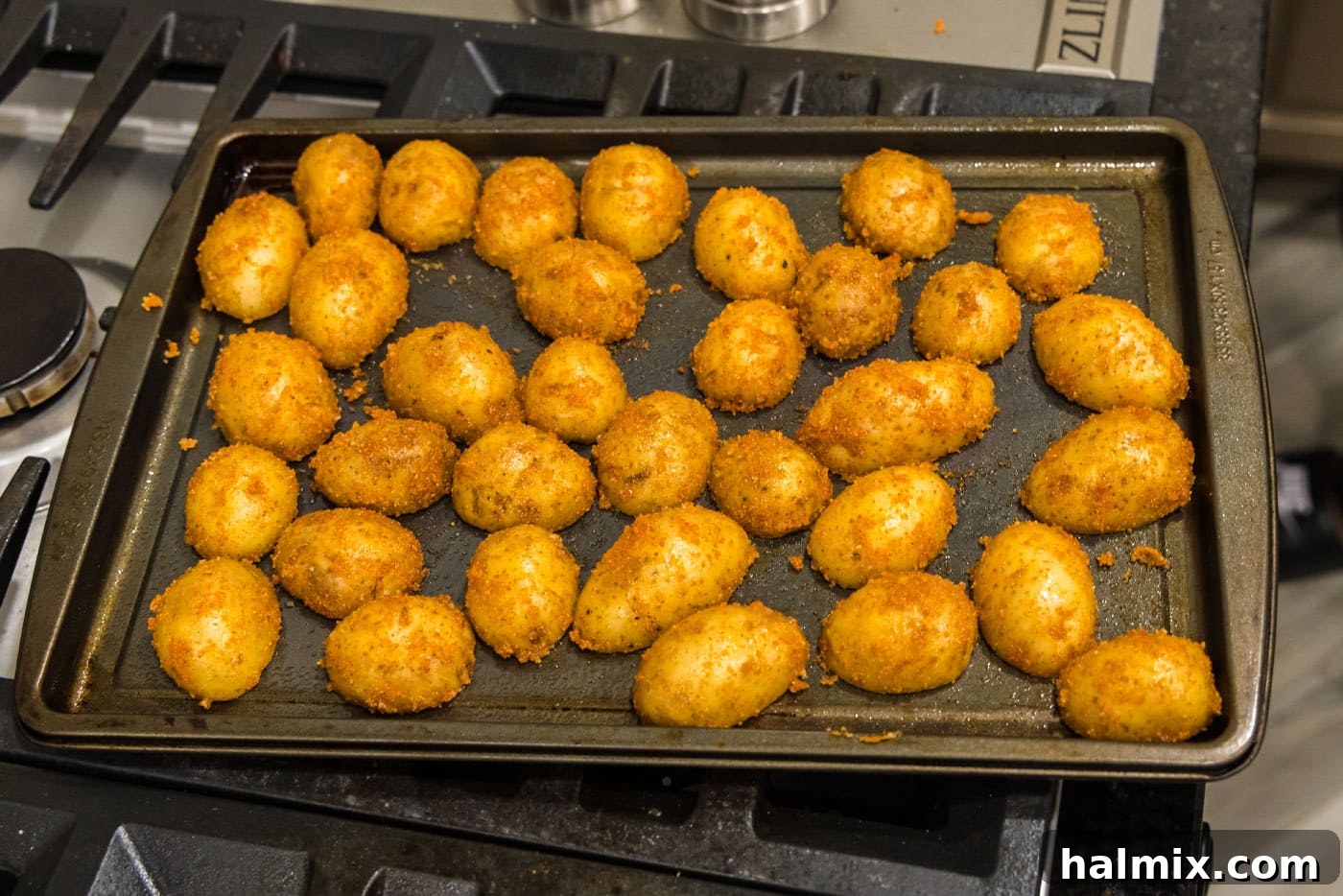 Sliced potatoes arranged cut-side down in a single layer on a prepared baking sheet