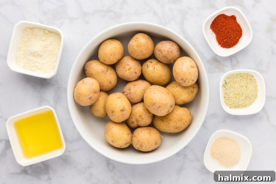 A collection of fresh ingredients laid out on a cutting board, including Yukon Gold potatoes, a block of Parmesan cheese, olive oil, and various spices