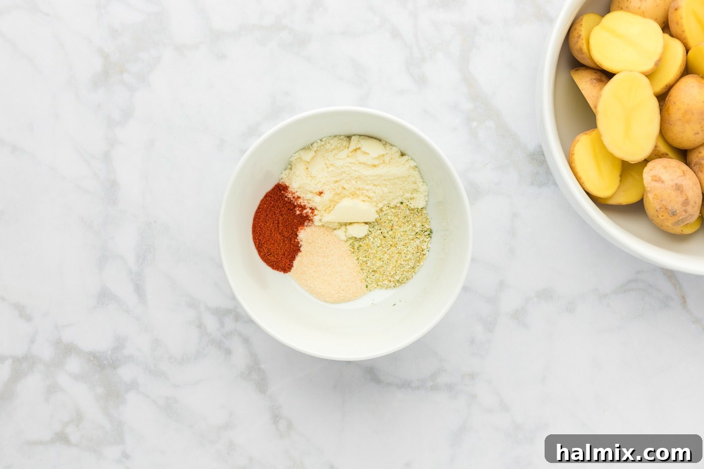 A small bowl holding the mixed parmesan cheese and spices for seasoning potatoes