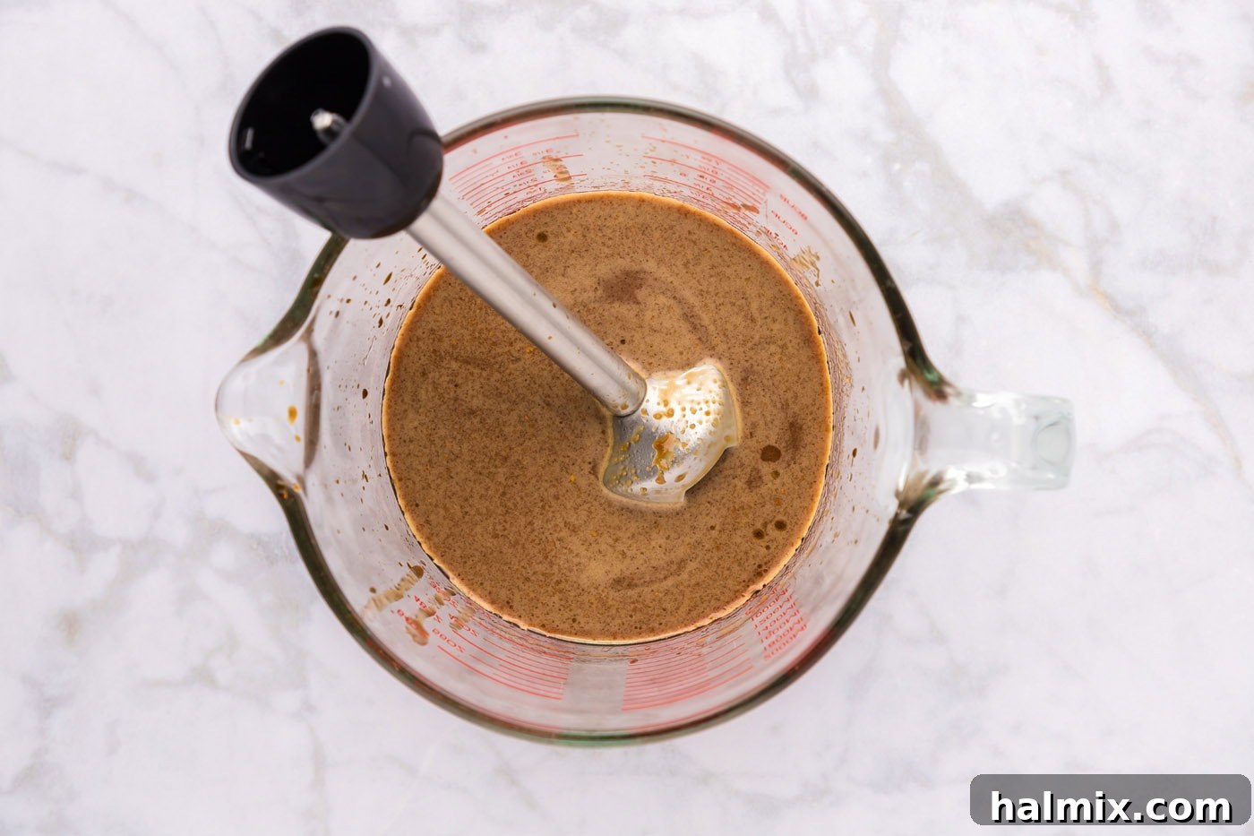 Teriyaki sauce being blended with an immersion blender