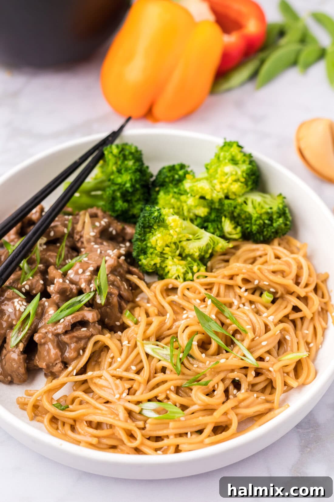 A bowl of Teriyaki Noodles served alongside steamed broccoli and a portion of beef teriyaki