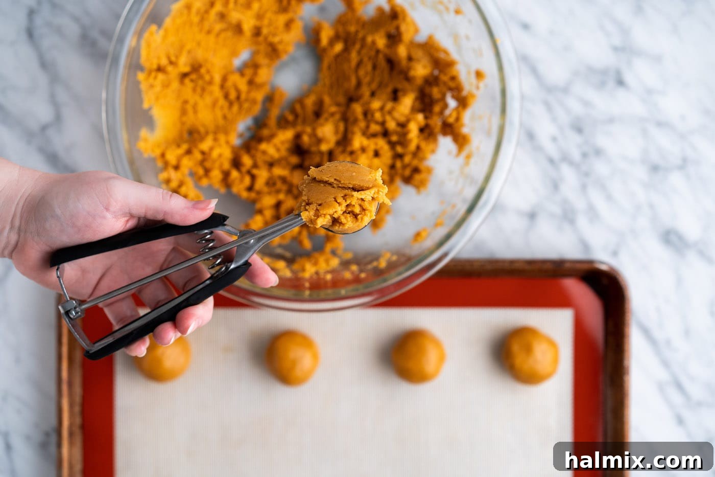 scooping peanut butter dough with a cookie scoop