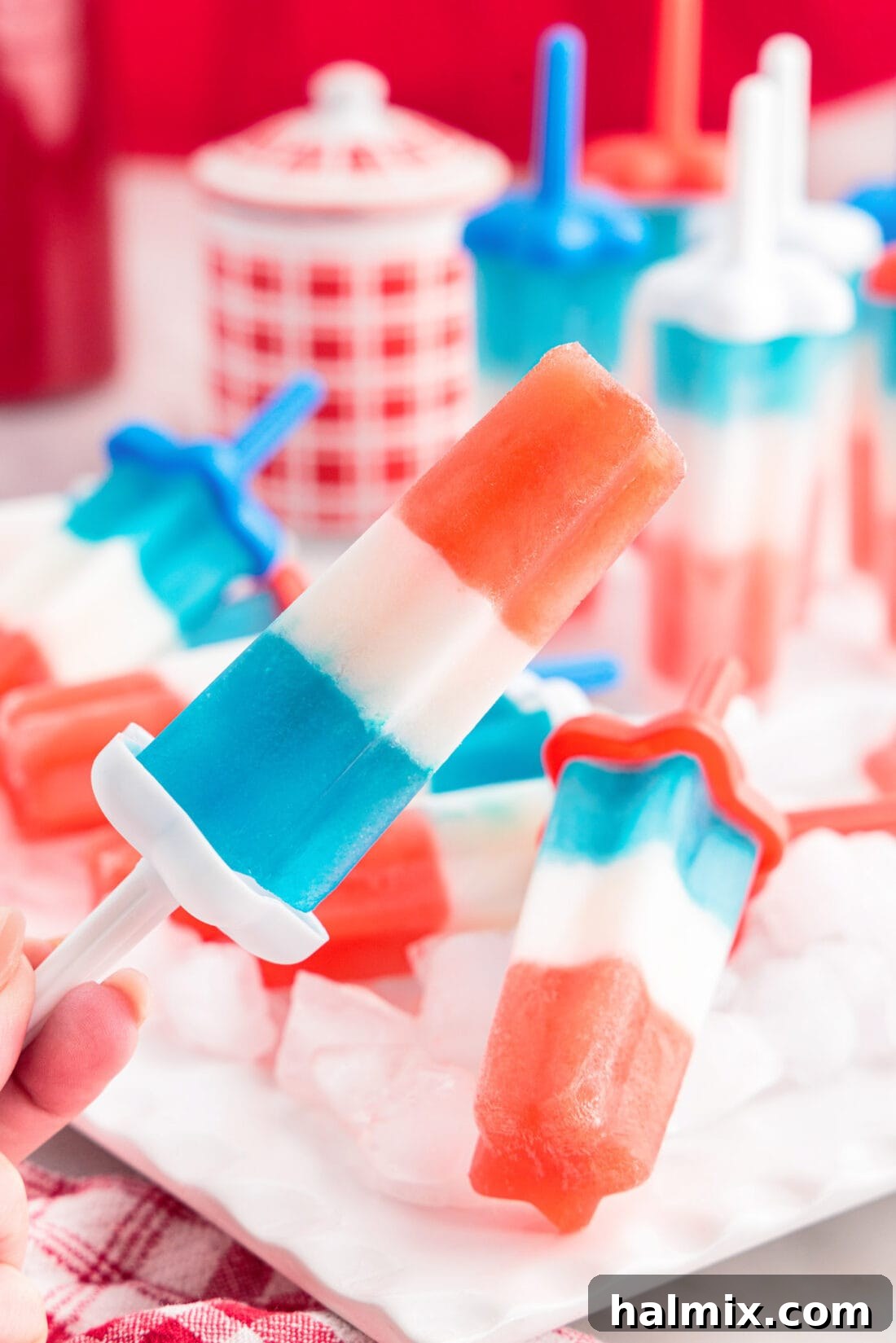 Delicious Homemade Patriotic Bomb Pops, featuring vibrant red, white, and blue layers, ready for a refreshing summer treat on the Fourth of July.