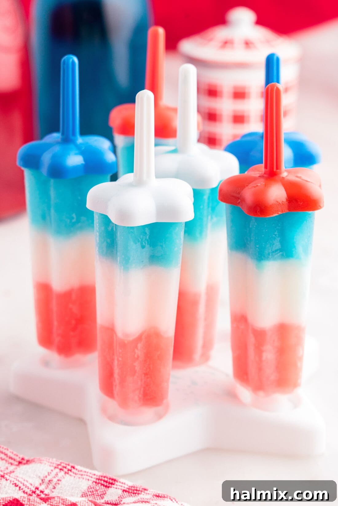 Patriotic Bomb Pops still in their molds, showcasing the perfect separation of red, white, and blue layers.