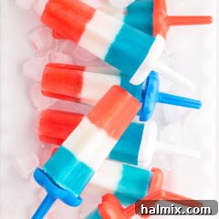 Patriotic Bomb Pops resting over ice, showcasing their vibrant layers.