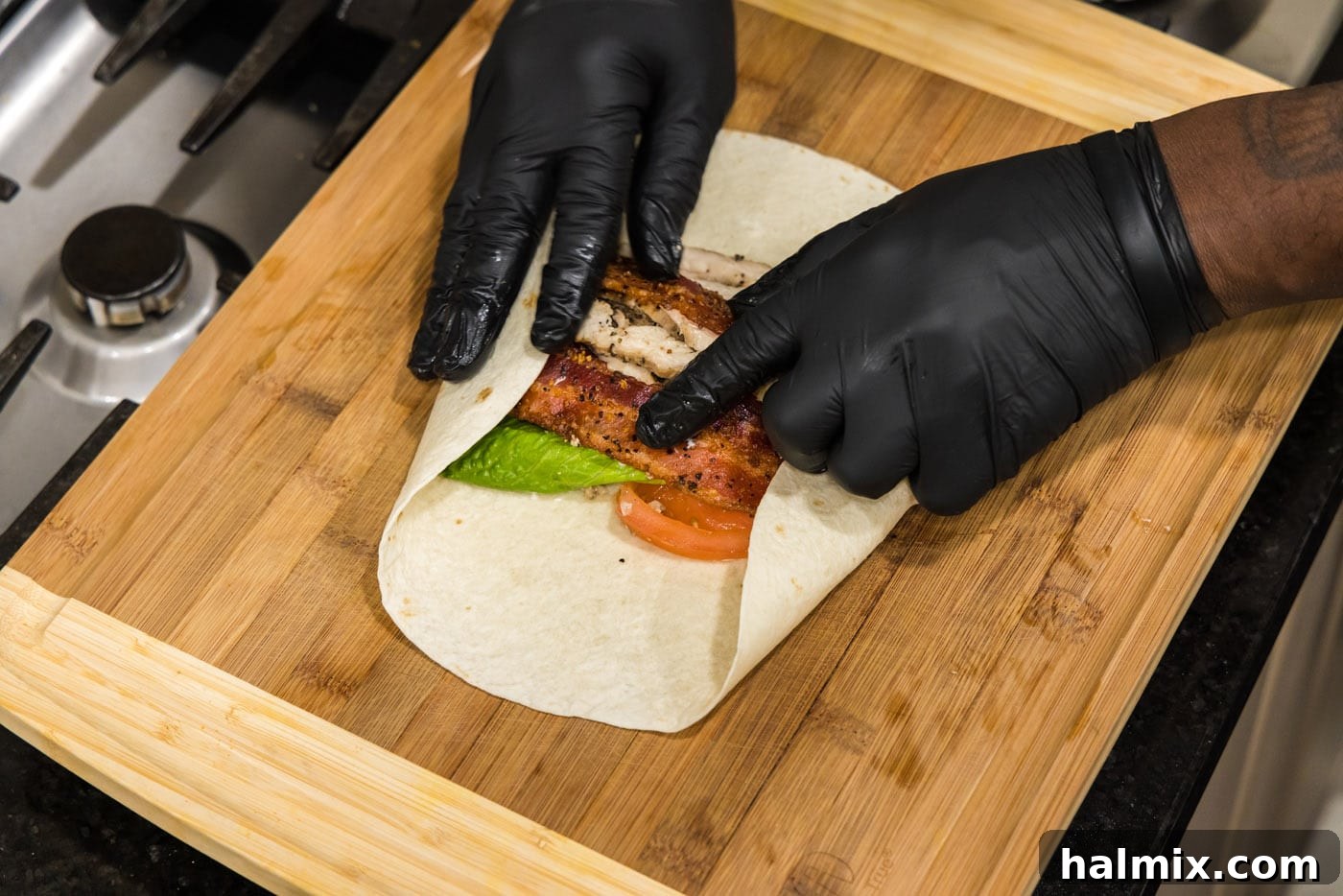 hands rolling chicken bacon ranch wrap
