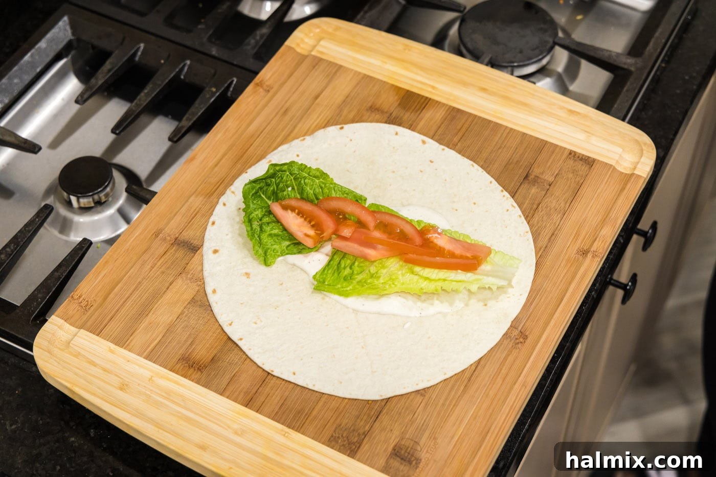 sliced tomato added on top of lettuce and ranch