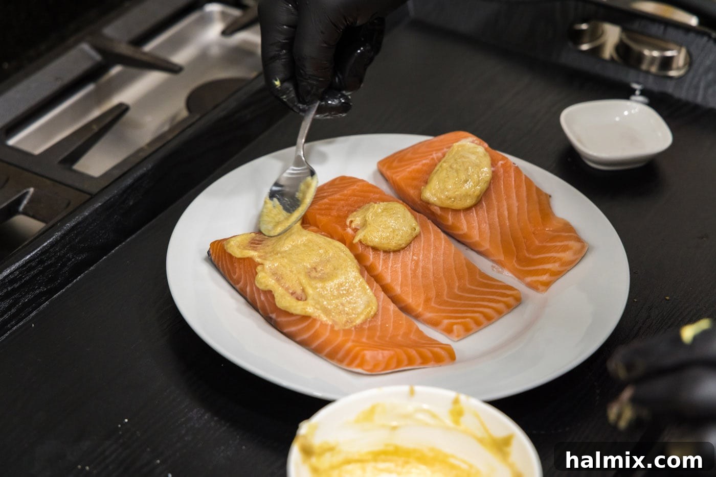 spoon spreading brown sugar glaze over salmon