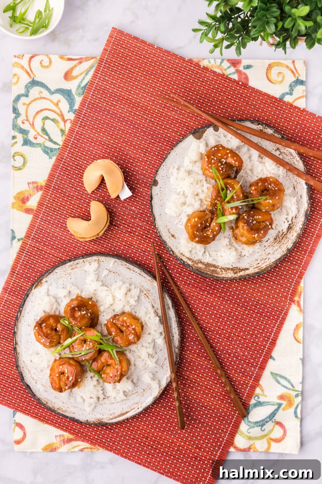 Two plates of Hunan Shrimp with chopsticks and fortune cookies, showcasing a delicious and vibrant meal.