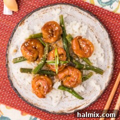 Plate of Hunan Shrimp served over rice and garlic green beans, a complete and appealing meal.