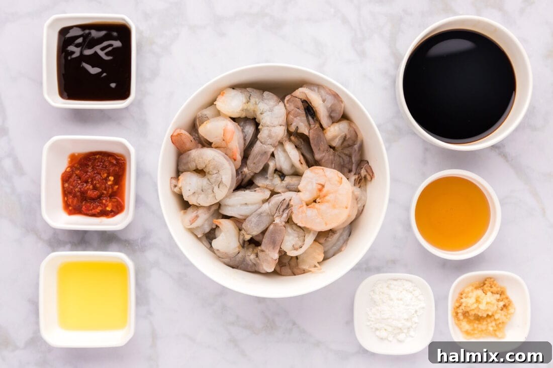 A selection of fresh ingredients laid out for making Hunan Shrimp, including shrimp, sauces, and aromatics.