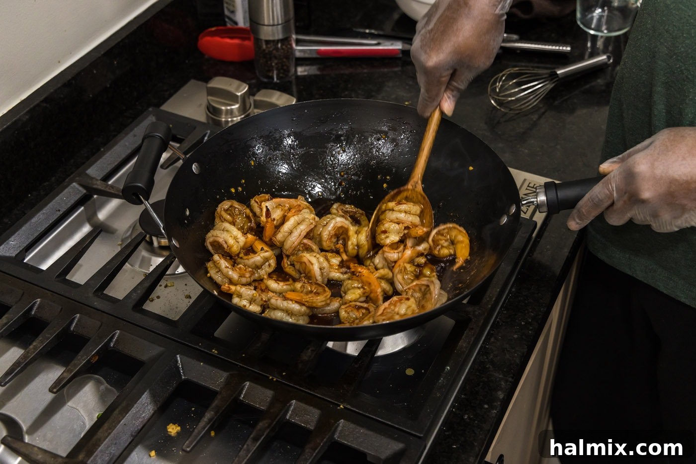 Tossing the shrimp in the spicy Hunan sauce, ensuring maximum flavor infusion.