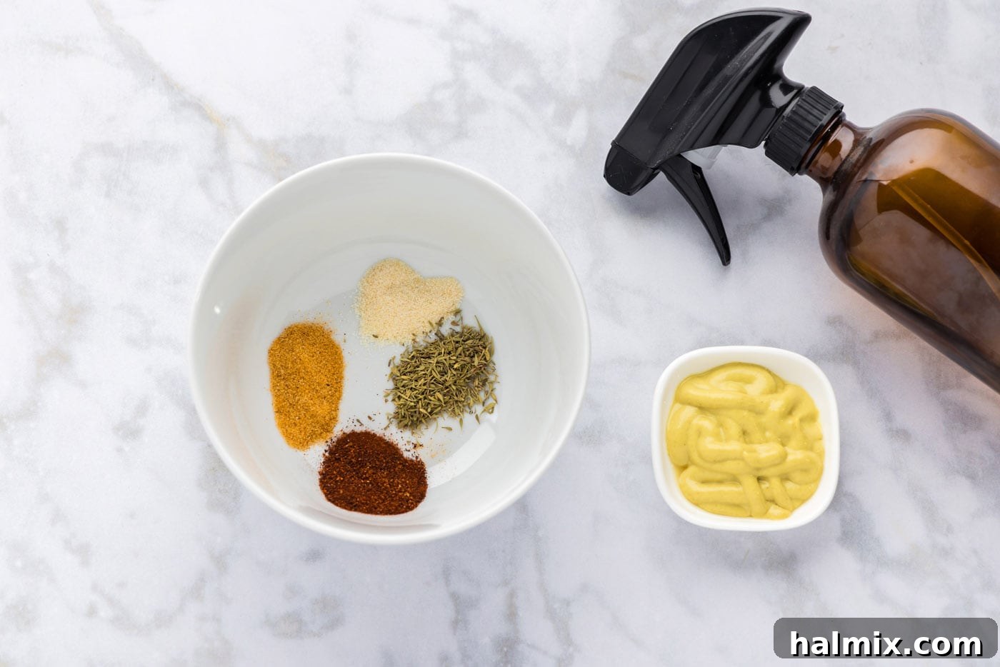 A bowl of mixed seasoning ingredients and a spray bottle containing the spritz mixture, essential for smoking beef short ribs.